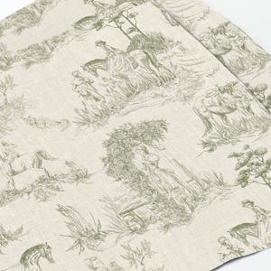 May include: A beige fabric with a repeating pattern of green line drawings of people riding horses and trees. The pattern is reminiscent of a toile fabric.