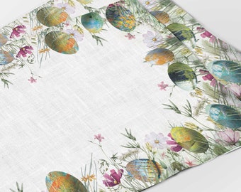 May include: White Easter-themed placemat with a colorful egg and floral design. The border features painted eggs in shades of blue, green, yellow, and orange, surrounded by wildflowers and greenery. The placemat has a textured appearance.