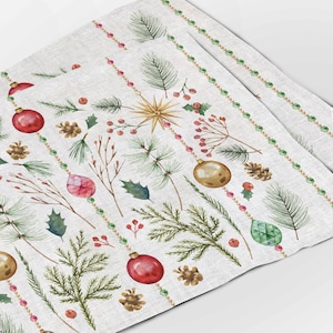 May include: Set of four Christmas-themed placemats with a white background and a repeating pattern of green pine branches, red and gold ornaments, and red berries. The placemats have a subtle linen texture.