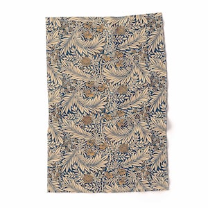Puede incluir: Un paño de cocina de color crema con un patrón floral azul y dorado. El patrón presenta hojas y flores estilizadas.