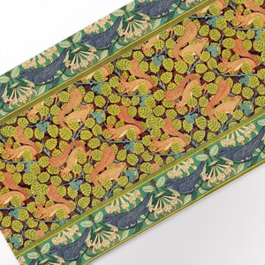 May include: A repeating pattern of squirrels and birds on a green background. The squirrels are orange and brown and the birds are blue. The pattern is framed by a border of green leaves and white flowers.