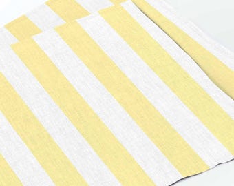 May include: Two pieces of fabric with a repeating pattern of yellow and white vertical stripes. The fabric has a textured appearance, and the stripes are of equal width. The overall look is clean and simple.