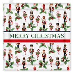 Pode incluir: Pega panelas branco com tema natalino com um padrão repetido de quebra-nozes, bengalas doces, azevinho e velas. As palavras "MERRY CHRISTMAS" são exibidas em texto verde sobre um fundo branco, emolduradas por uma borda vermelha e azul.