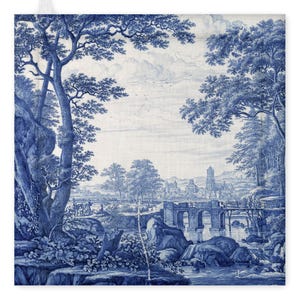 Puede incluir: Un textil cuadrado decorativo azul y blanco con una escena de paisaje. El diseño incluye árboles, un río, un puente y una ciudad distante. La obra de arte recuerda a la porcelana clásica azul y blanca.