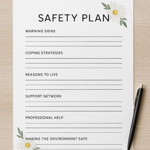 以下が含まれることがあります： 「SAFETY PLAN」の文字が上部に書かれた白い紙。警告サイン、対処戦略、生きる理由、サポートネットワーク、専門家の助け、環境を安全に保つためのセクションが含まれています。黒いペンが右側に置かれています。