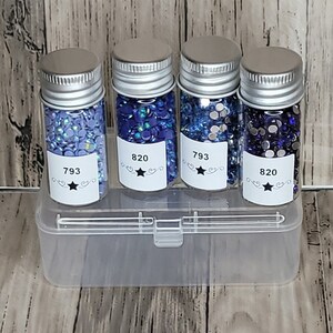 May include: Four small glass jars with silver lids filled with blue and clear rhinestones. The jars are labeled with numbers 793 and 820. The jars are in a clear plastic storage box.