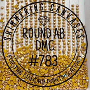 May include: A tray filled with round, yellow-gold AB DMC diamond painting drills. The image features a black circular logo with the text "Shimmering Canvas" and "Round AB DMC #783" and "For the Diamond Painting Addict".