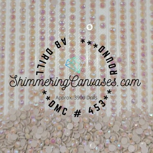 May include: A close-up of iridescent white round diamond-shaped beads, with the text "Shimmering Canvases.com Approx. 3900 Drills **DMC # 453** ROUND*** AB DRILL" printed on a white background.