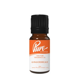 May include: A 10 ml amber glass bottle of gingerbread scented fragrance oil. The bottle has a black cap and a white label with the text "Pure Scented", "100% Pure Fragrance Oil", "Gingerbread", "10ml", and "www.PureScented.com".