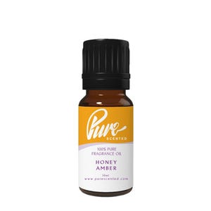 May include: A small amber glass bottle with a black cap. The label features the word "Pure" in a script font, along with the text "100% Pure Fragrance Oil", "Honey Amber", and "10ml". The website address www.purescented.com is also visible.