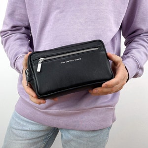 May include: A black leather zipped pouch with a silver zipper and the text "PDL LEATHER STUDIO" printed on the front.