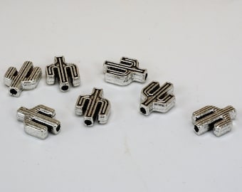 May include: Eight silver cactus-shaped beads with black outlines. The beads are small and have a hole in the center for stringing.