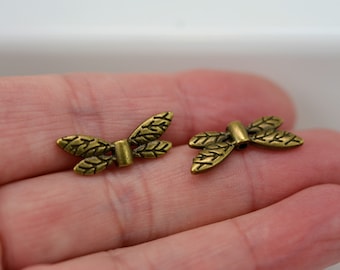 May include: Two gold-toned metal butterfly charms with a leaf design. The charms have a hole in the center for attaching to jewelry or other crafts.