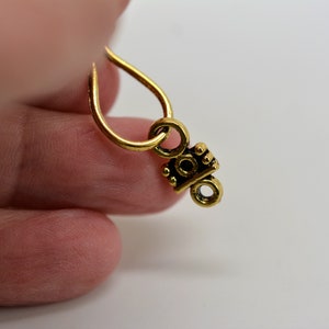 Peut inclure: Breloque en m&eacute;tal dor&eacute; avec un motif d&eacute;coratif. Le breloque a une boucle en haut pour l'attacher &agrave; un collier ou un bracelet.
