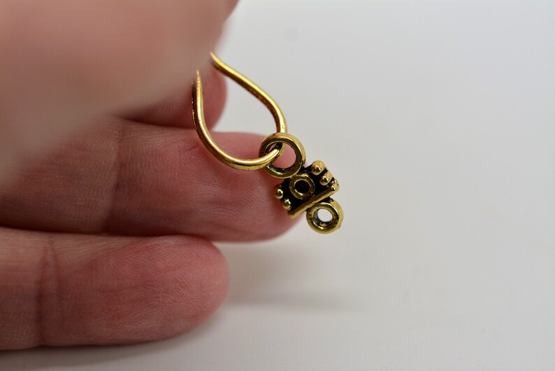 Peut inclure: Breloque en m&eacute;tal dor&eacute; avec un motif d&eacute;coratif. Le breloque a une boucle en haut pour l'attacher &agrave; un collier ou un bracelet.