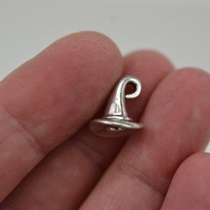 May include: A silver charm in the shape of a witch's hat.