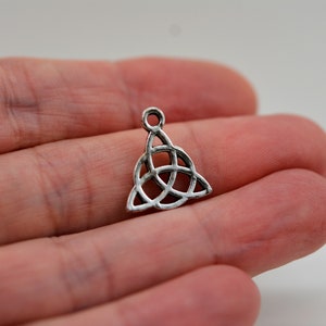 May include: Silver charm in the shape of a Celtic knot, a triangular design with interlacing loops.