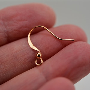 May include: A gold-toned earring hook with a small ball at the end.