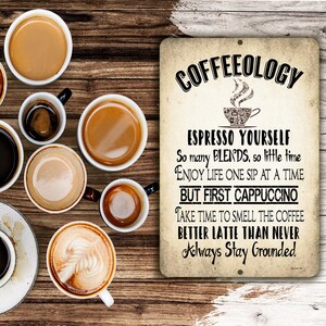 May include: A rectangular metal sign with a distressed beige finish featuring black text that reads COFFEEOLOGY, ESPRESSO YOURSELF, So many BLENDS, so little time, ENJOY LIFE ONE SIP AT A TIME, BUT FIRST CAPPUCCINO, TAKE TIME TO SMELL THE COFFEE, BETTER LATTE THAN NEVER, Always Stay Grounded.