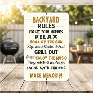 May include: A rectangular metal sign with the words "BACKYARD RULES" in black and gold. The sign lists rules such as "Relax", "Grill Out", and "Make Memories". The sign is mounted on a wooden table.