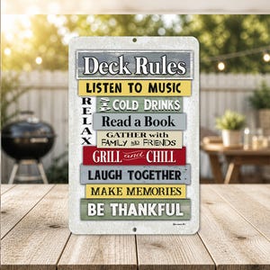 May include: A rectangular metal sign with the words "Deck Rules" at the top. Below, colorful horizontal bars list rules like "Listen to Music," "Cold Drinks," and "Grill and Chill." The sign is on a wooden table.