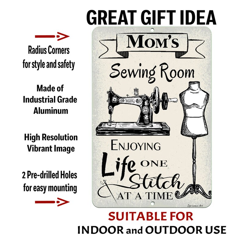 May include: A rectangular metal sign with the text "Mom's Sewing Room" and an illustration of a vintage sewing machine and dress form. The sign also includes the text "Enjoying Life One Stitch at a Time" and is suitable for indoor and outdoor use.