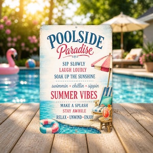 May include: A rectangular sign with the words "Poolside Paradise" in blue and red script. The sign includes phrases like "Summer Vibes" and "Make a Splash." A beach chair, umbrella, and pool are visible in the background.
