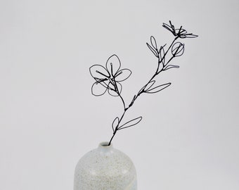 Branch of prunus (decorative cherry tree) in black wire and soliflore in white enameled ceramic, metal wire and stoneware