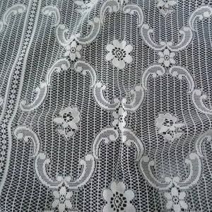 May include: White lace fabric with a delicate floral pattern. The fabric is woven in a fine mesh and has a soft, flowing texture.