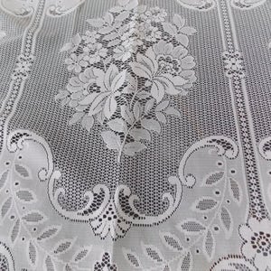 May include: White lace fabric with a floral pattern. The lace has a delicate, intricate design with small flowers and leaves.