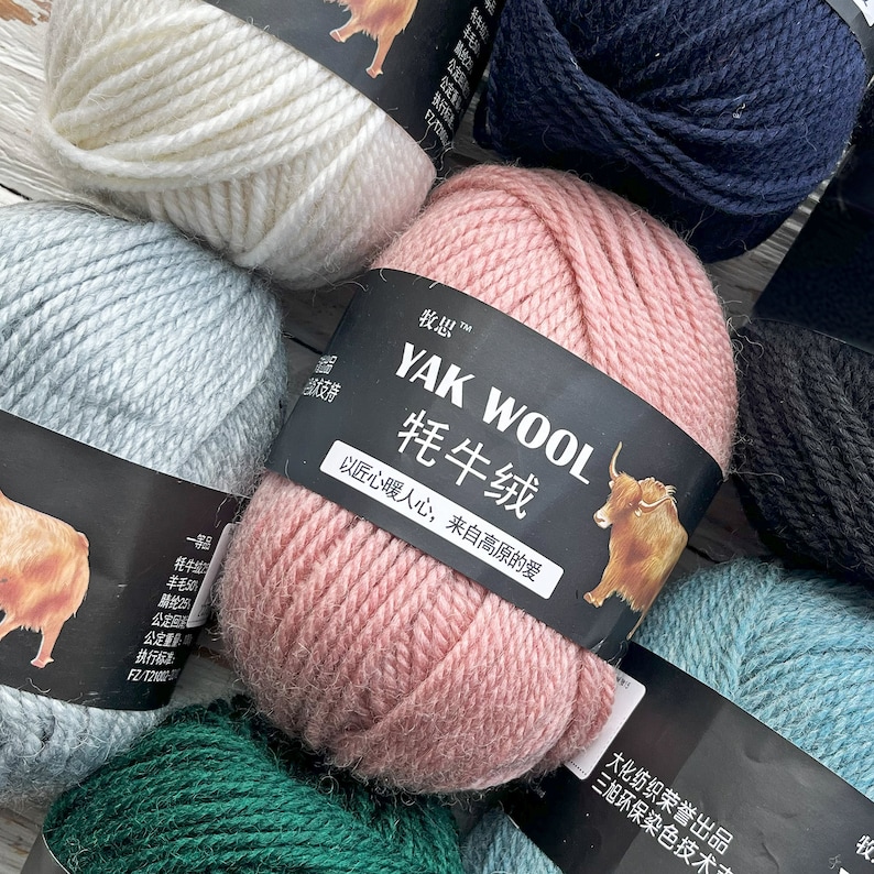 May include: Assortment of yarn skeins in various colors, including white, light blue, pink, dark blue, black, and green. The yarn is labeled "YAK WOOL 牦牛绒" with the text "以匠心暖人心, 来自高原的爱" in Chinese characters.