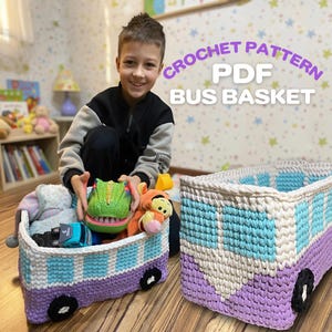 May include: A crochet pattern for a bus-shaped basket. The basket is mainly purple with white and light blue details, and black wheels. The text "CROCHET PATTERN PDF BUS BASKET" is visible. The basket is filled with toys.