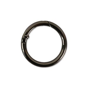 Puede incluir: Una argolla metálica circular con cierre de resorte y acabado en color gris plomo pulido. El anillo cuenta con un segmento articulado que se abre hacia adentro, permitiendo enganchar objetos. La pieza tiene una superficie lisa y brillante.
