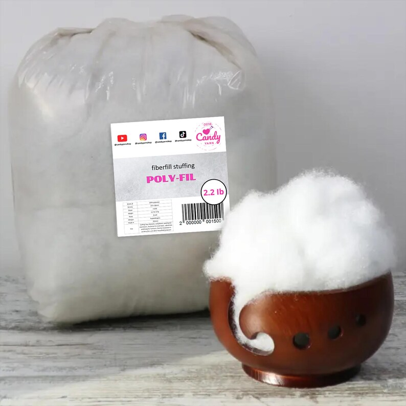 May include: A large bag of white Poly-Fil fiberfill stuffing, with a label indicating 2.2 lb. A small wooden bowl holds a portion of the fluffy material. The label includes the text "Candy Yarn".