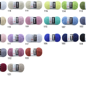 May include: A collection of yarn balls in various colors, including beige, pink, blue, green, and red. Each ball has a label with the brand name "YamArt" and the word "Elegance". The balls are numbered from 101 to 123.