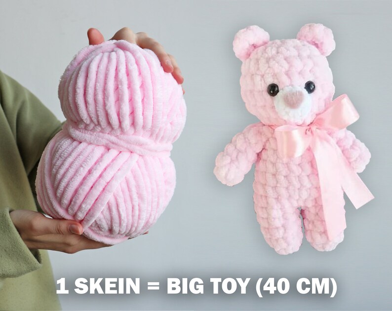 K&ouml;nnte beinhalten: Eine Kn&auml;uel rosa Garn, ausreichend f&uuml;r einen 40 cm gro&szlig;en Pl&uuml;schteddyb&auml;r. Der Text "1 SKEIN = BIG TOY (40 CM)" ist unter dem Garn sichtbar.