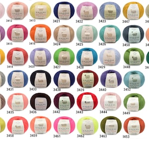 May include: A collection of colorful yarn balls, each labeled with a unique number. The yarn is available in a wide range of colors, including pink, yellow, blue, green, and orange. The yarn is labeled "GAZZAL BABY COTTON".