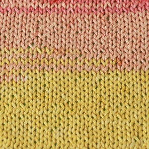 May include: Close-up of a knitted fabric with a gradient of pink and yellow colors. The fabric is made of a soft, textured yarn.