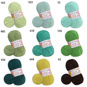Puede incluir: Una colecci&oacute;n de ovillos de hilo Alize Cotton Gold en varios colores, incluyendo tonos de verde, turquesa, amarillo y marr&oacute;n. Cada ovillo est&aacute; etiquetado con un n&uacute;mero y una muestra de color, ideal para tejer y hacer ganchillo.