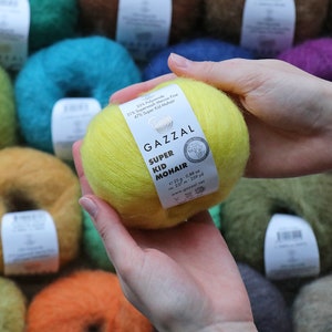 May include: A ball of yellow yarn labeled "GAZZAL SUPER KID MOHAIR" with the composition 31% Superwash Merino Fine, 47% Super Kid Mohair, 1.25 oz, 237 m, 259 yd.