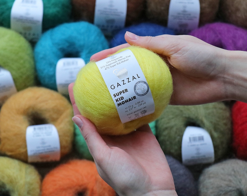 May include: A ball of yellow yarn labeled "GAZZAL SUPER KID MOHAIR" with the composition 31% Superwash Merino Fine, 47% Super Kid Mohair, 1.25 oz, 237 m, 259 yd.