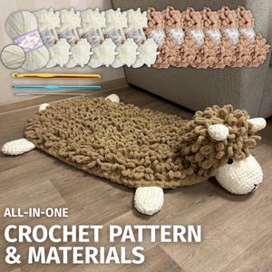 May include: A crochet sheep rug with a brown body and white accents. The image also shows cream and peach yarn skeins, crochet hooks, and the text "ALL-IN-ONE CROCHET PATTERN & MATERIALS".