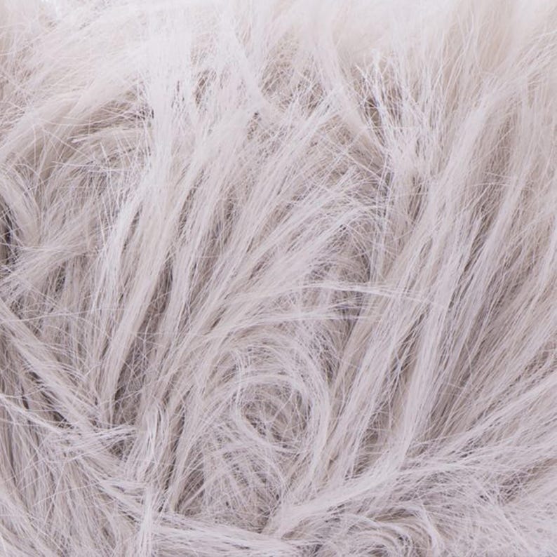 May include: Close-up of a bundle of light gray yarn with a fluffy, textured appearance. The yarn fibers are long and flowing, creating a soft, cloud-like effect. Ideal for knitting or crocheting projects.
