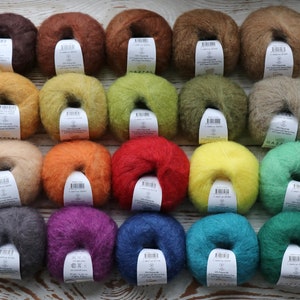 May include: Twenty skeins of yarn in various colors, including brown, orange, red, yellow, green, blue, purple, and gray. Each skein is wrapped in a circle and has a label with the brand name "GAZZAL" and other information.