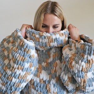 May include: An oversized sweater with a high neck, featuring blue, white and brown stripes.