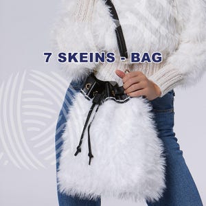 May include: A white faux fur bucket bag with a black leather top and drawstring closure. The bag has a black shoulder strap and a gold-colored clasp. The text "7 SKEINS - BAG" is printed on the image.