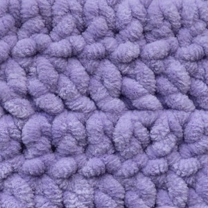 K&ouml;nnte beinhalten: Nahaufnahme eines weichen, violetten, flauschigen Stoffes mit einem strukturierten, gewebten Muster.
