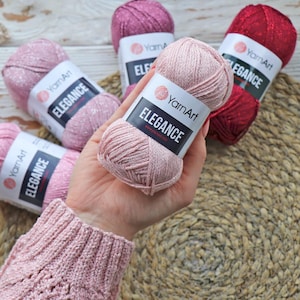 May include: Pink yarn ball with glitter, labeled "YarnArt Elegance".