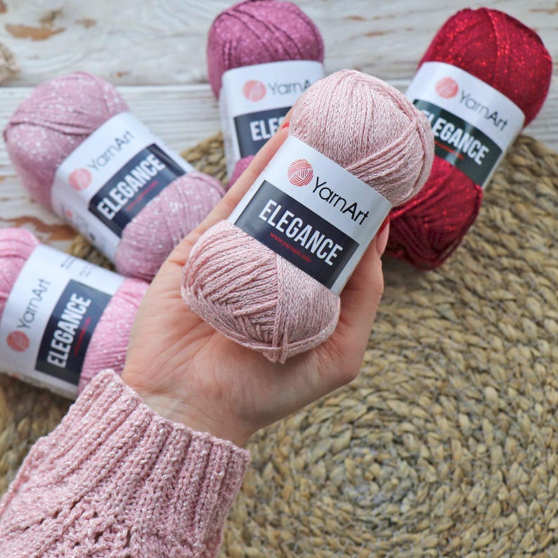 May include: Pink yarn ball with glitter, labeled "YarnArt Elegance".