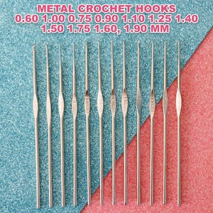 May include: A set of 11 metal crochet hooks on a blue and pink sparkly background. The hooks are labelled with their sizes in millimetres: 0.60, 1.00, 0.75, 0.90, 1.10, 1.25, 1.40, 1.50, 1.75, 1.60, 1.90 mm.